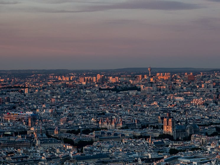 The skyline of Paris from the Tour Montparnasse bathed in a pink sunset glow
